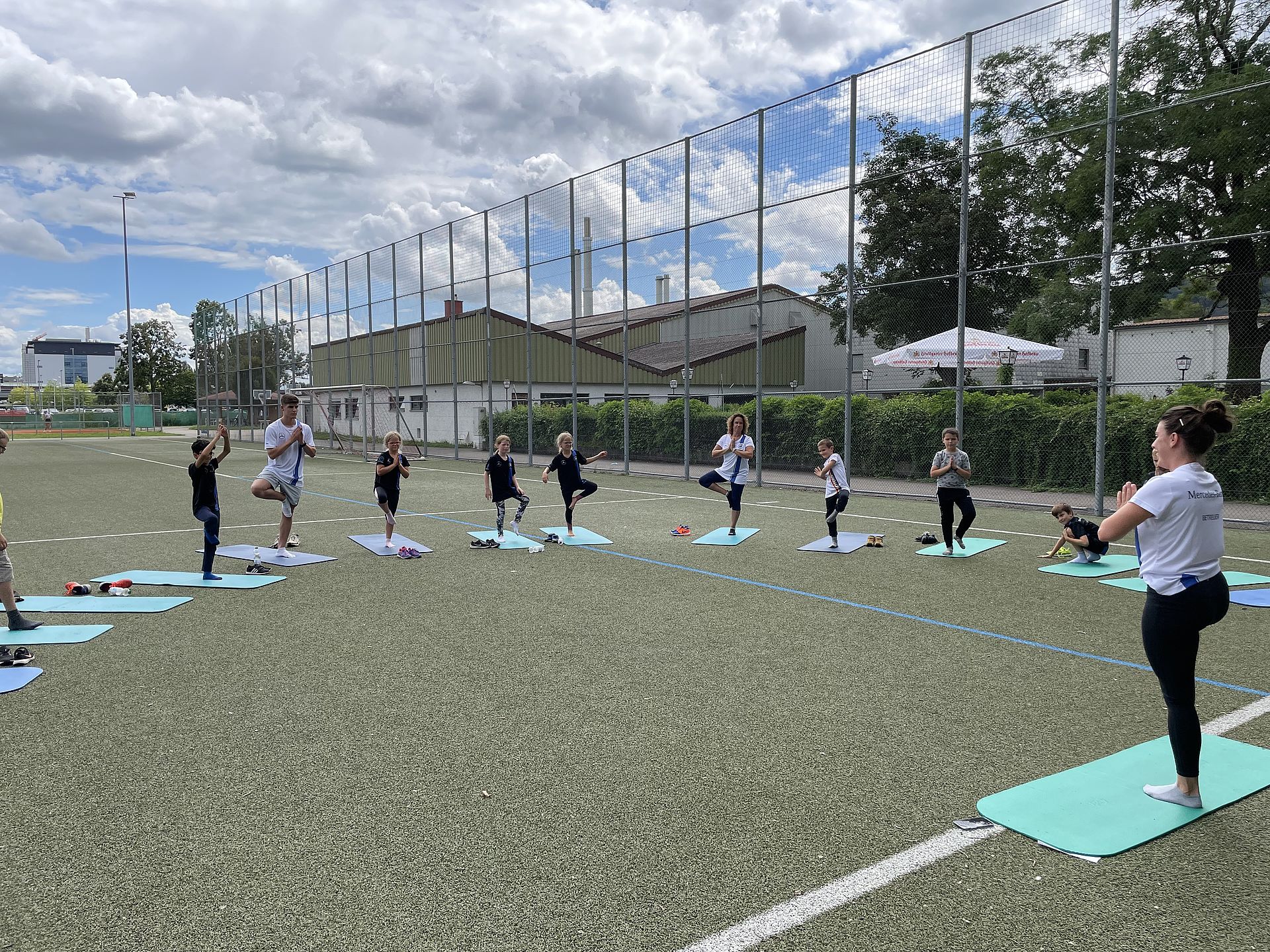 Eiune Gruppe Kinder macht Yogaübungen beim Sportcamp.